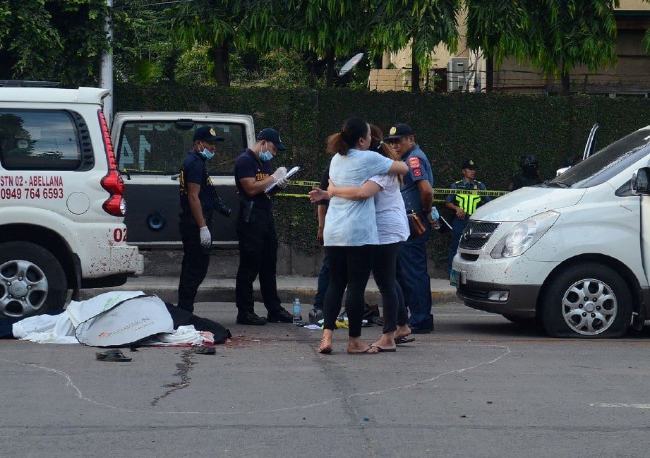 ANGGOTA keluarga  David Navarro berpelukan meratapi kematian Datuk Bandar Clarin itu yang maut ditembak lelaki bersenjata di Cebu, hari ini. - AFP