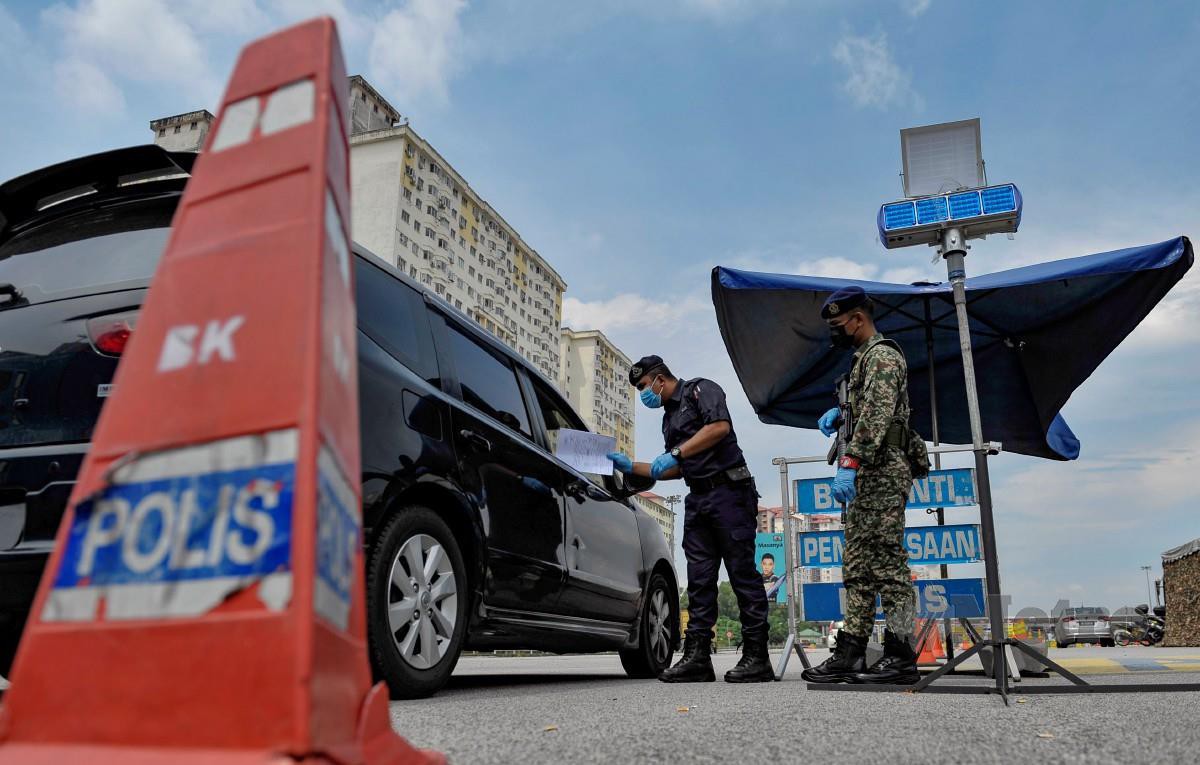 ANGGOTA polis bersama tentera memeriksa kenderaan yang melalui SJR berhampiran Plaza Tol Sungai Besi, Kuala Lumpur berikutan pelaksanaan PKP.  FOTO Aizuddin Saad.
