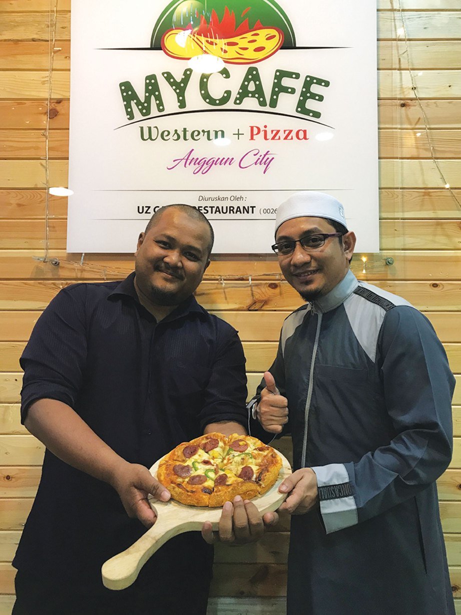 ZUHDI (kanan) dan Adik Mohamad menampilkan kelainan apabila mengetengahkan menu piza dengan sentuhan selera tempatan.