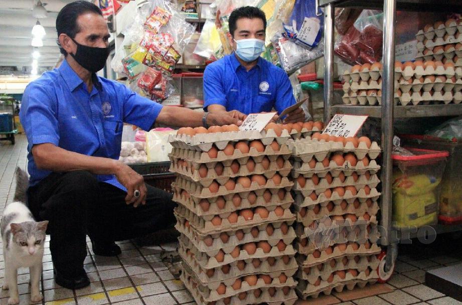 MOHAMAD Yusrizal (kanan) bersama Pengerusi Persatuan Peniaga-Peniaga Pasar Besar Alor Setar, Fauzi Saari melihat harga telur ayam  yang dijual di Pasar Besar Alor Setar. FOTO AMRAN HAMID