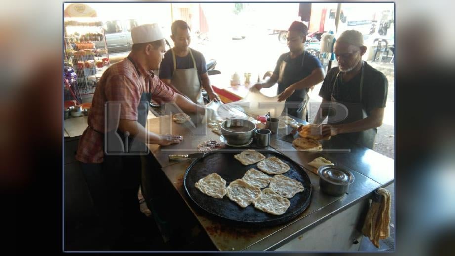Basharuddin (kiri) bersama tiga pekerjanya menebar roti canai pada satu masa di atas meja sama. FOTO Nor Farhani Che Ad