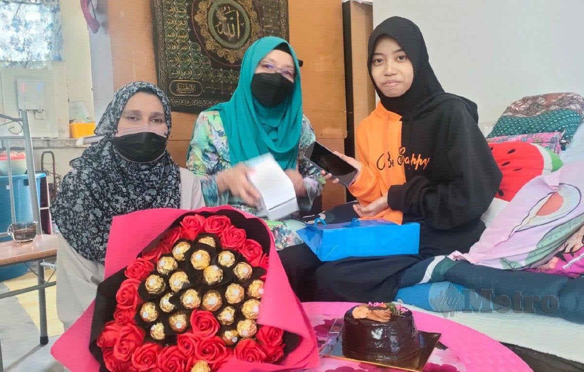 NUR Fatihah (kanan) menerima hadiah sempena hari lahirnya daripada Zuraini (tengah). FOTO Zuliaty Zulkiffli