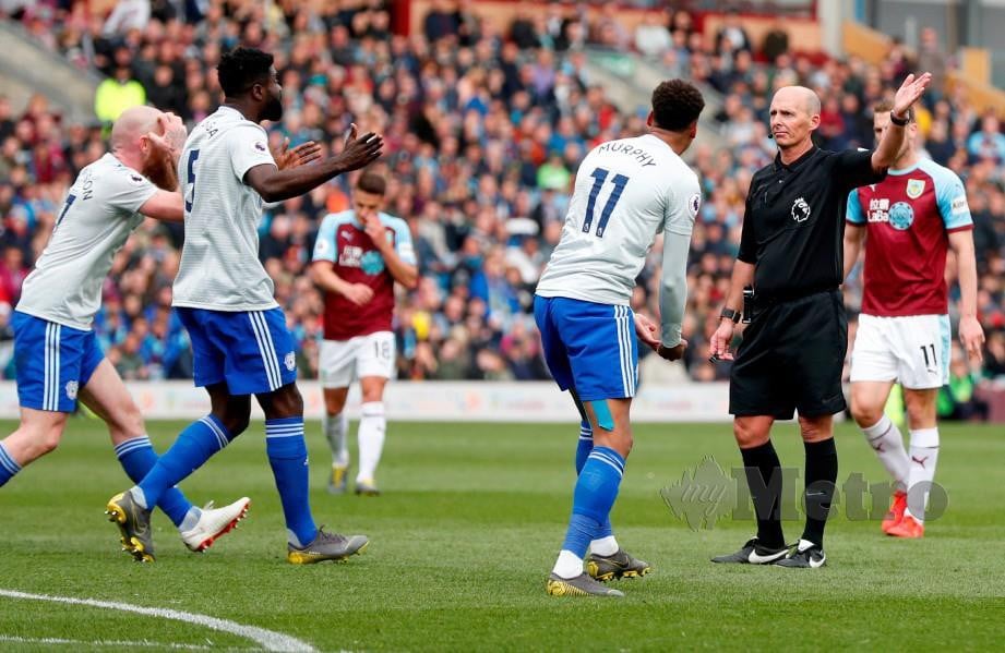 PENGADIL Dean (kanan) tidak mengendahkan rayuan pemain Cardiff, Bruno Ecuele Manga untuk mendapatkan sepakan penalti. — FOTO Reuters