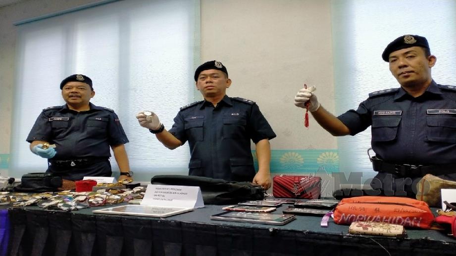TOK Beng Yeow (tengah) menunjukkan barang rampasan dari Geng Tailong. FOTO OMAR AHMAD