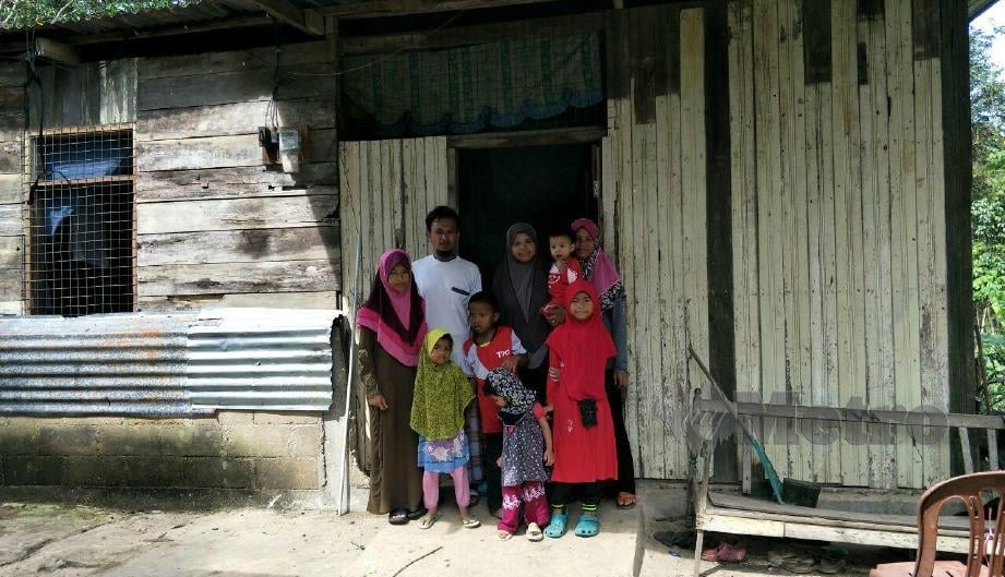 M Busra bersama isteri dan anaknya di rumah usang dibina semula di tapak asal selepas dihanyutkan banjir pada Disember 2014 di tepi Sungai Galas, Kampung Lembaga, Gua Musang. FOTO Ramli Ibrahim. 