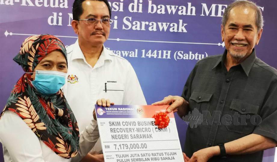 USAHAWAN kek lapis, Zubaidah mewakili semua penerima pembiayaan Skim Pemulihan Perniagaan Mikro COVID-19 Sarawak daripada Wan Junaidi. FOTO Mohd Roji Kawi