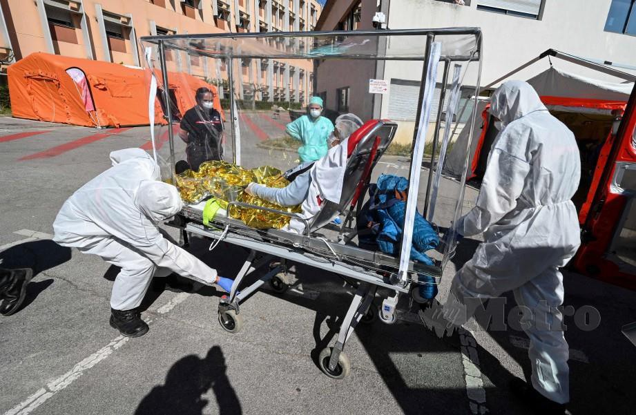 PETUGAS barisan hadapan Perancis membawa pesakit Covid-19 ke hospital. FOTO AFP