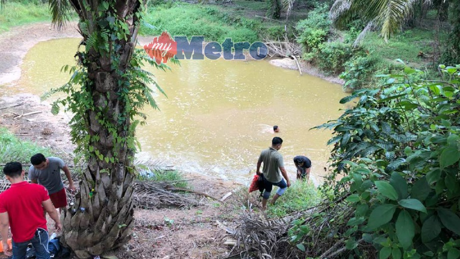 ANGGOTA polis melakukan pencarian dalam kolam di kebun kelapa sawit. FOTO Ihsan PDRM