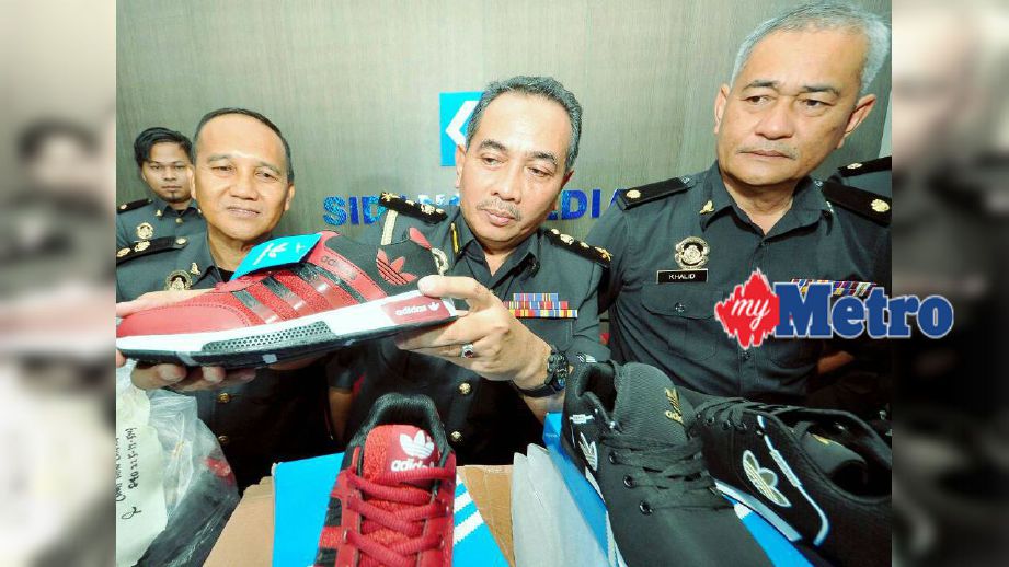 Yahya menunjukkan kasut tiruan yang dirampas oleh KPDNKK Sabah di Penampang. FOTO Mohd Adam Arinin