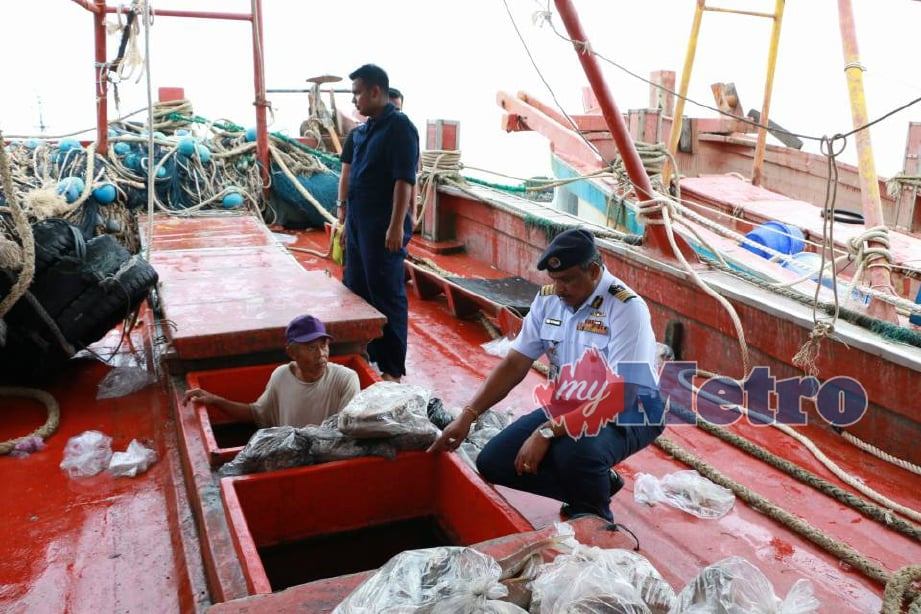Pannir memeriksa hasil tangkapan bot nelayan Vietnam yang ditahan selepas menceroboh perairan negara. FOTO Rosli Ilham