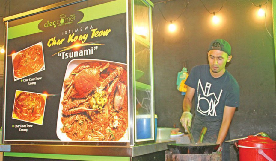 ARHAM Syafiq memasak Char Kuetiau Tsunami yang dipesan pelanggan.