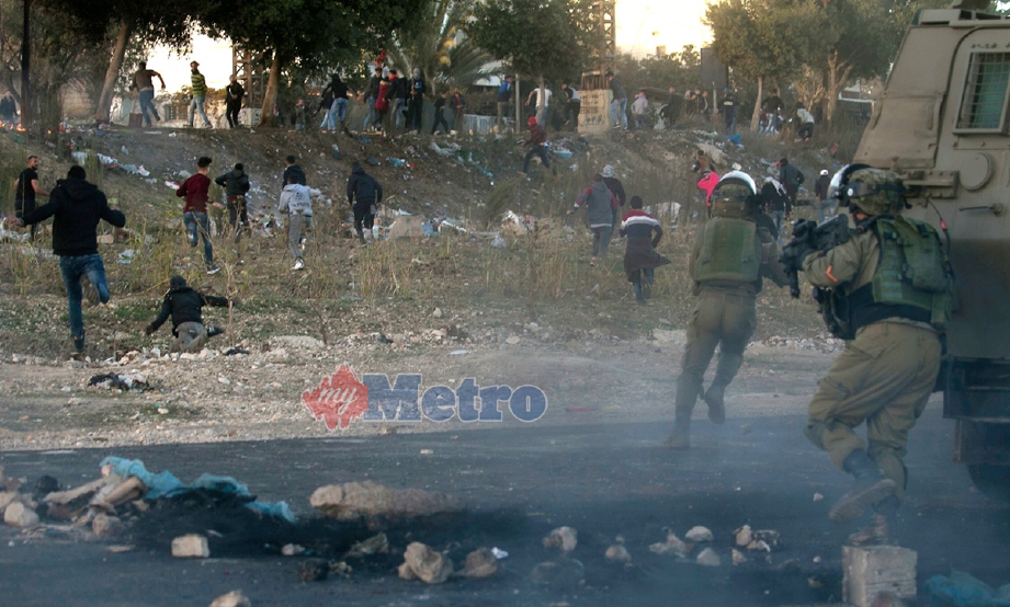 Tentera Israel mengejar penduduk Paletsin yang menyertai bantahan di Nablus, Tebing Barat. - Foto AFP