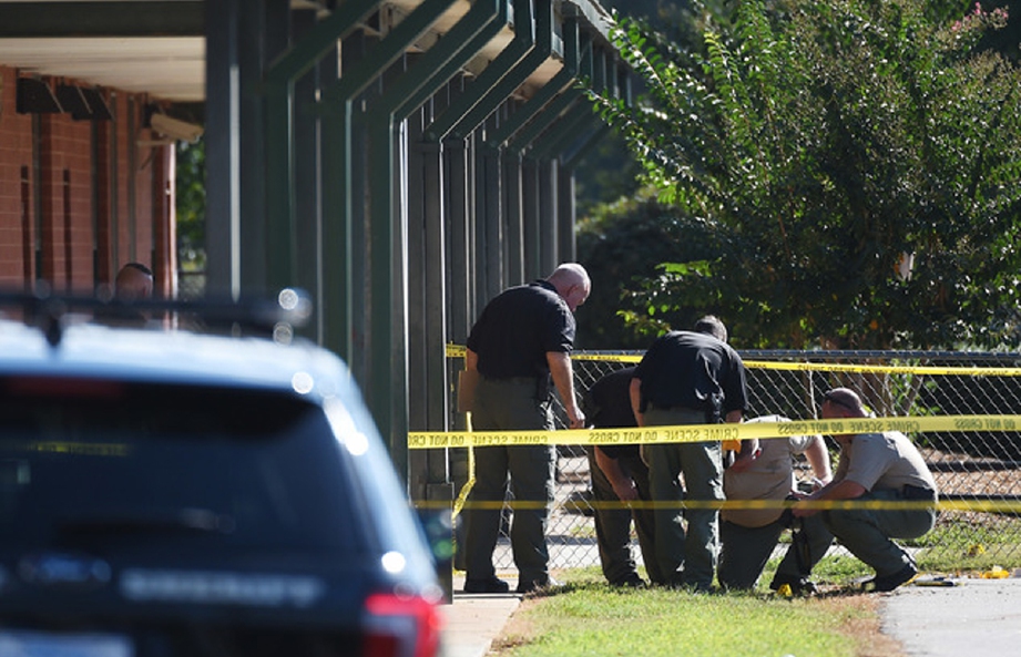 Anggota polis memeriksa lokasi kejadian di Sekolah Rendah Townville selepas seorang remaja melepaskan tembakan menyebabkan dua murid dan seorang guru cedera. - Foto AP