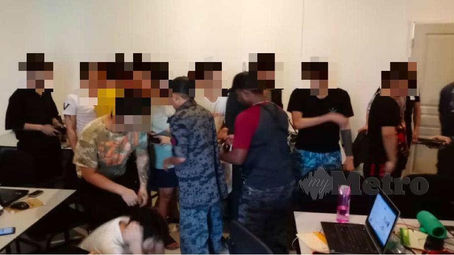 Anggota JIM memeriksa warga China yang disyaki menjalankan kegiatan penipuan dalam talian di sebuah premis di Bandar Meru Raya, Ipoh semalam. Foto Ihsan JIM Perak