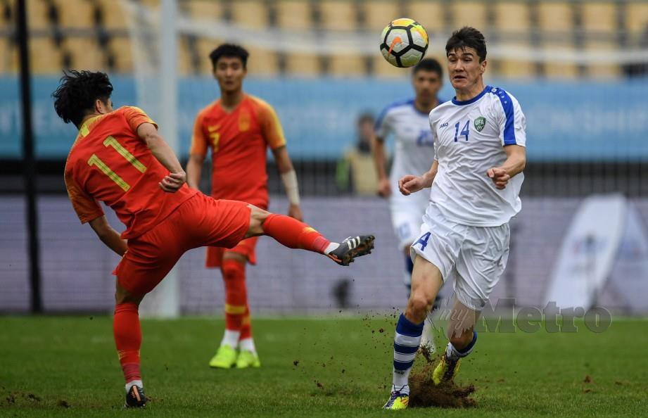 SHOMURODOV (kanan) berebut bola dengan pemain China, Hao Junmin (kiri) pada aksi penentuan tempat ketiga. — FOTO AFP