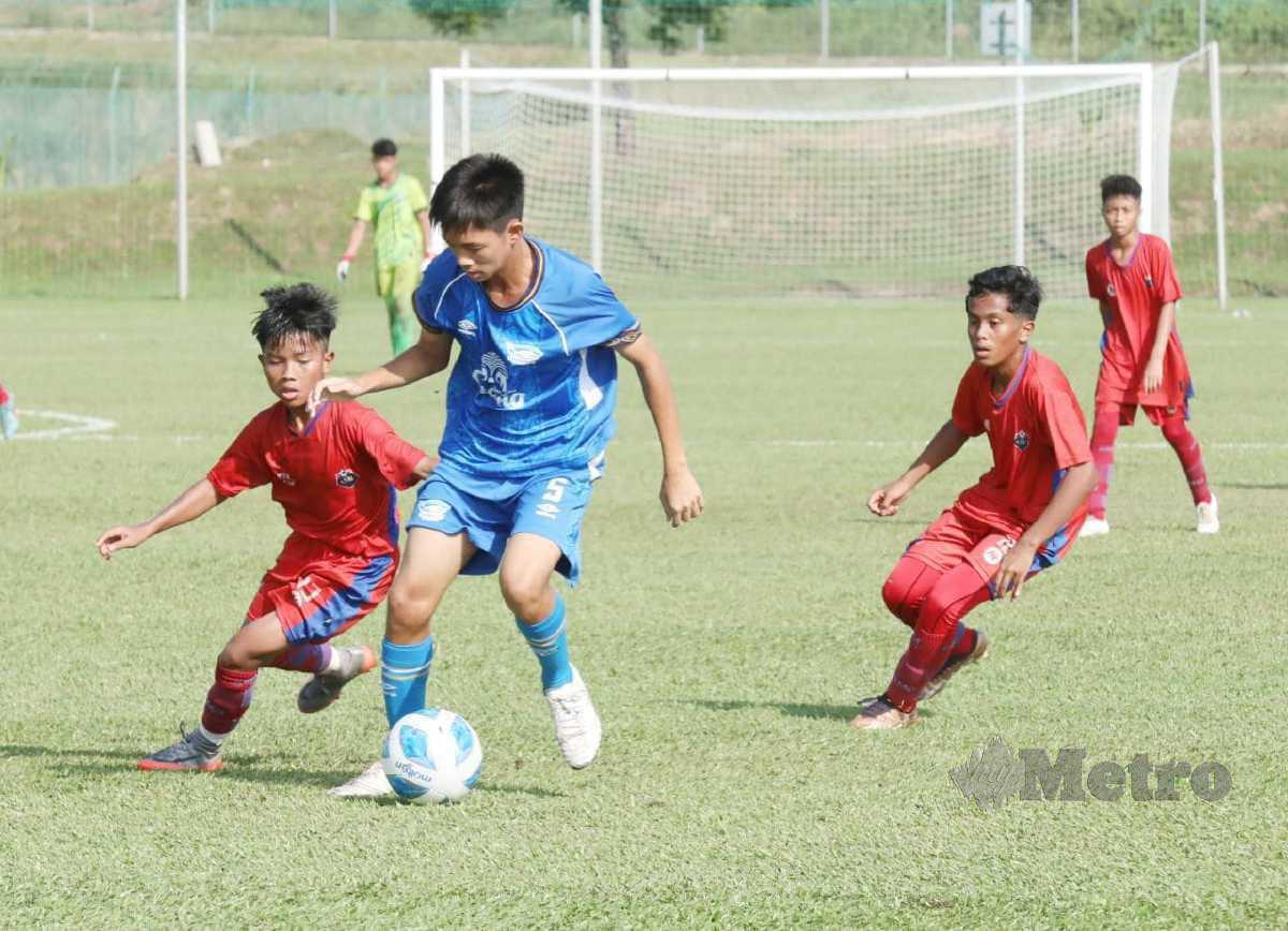 AKSI pemain pasukan Chonburi FC (jersi biru) dan AMD Dream pada perlawanan bawah 13 tahun di kejohanan Piala Supermokh 2023 dekat Akademi Bolasepak Negara Mokhtar Dahari (AMD), Gambang. FOTO MOHD RAFI MAMAT