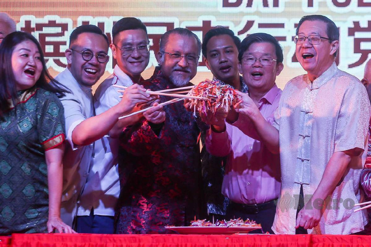 CHOW (dua dari kanan) dan Pengerusi DAP, Lim Guan Eng (kanan) serta kepimpinan DAP Pulau Pinang menggaul Yee Sang pada Majlis Rumah Terbuka Tahun Baru Cina DAP Pulau Pinang. FOTO Danial Saad