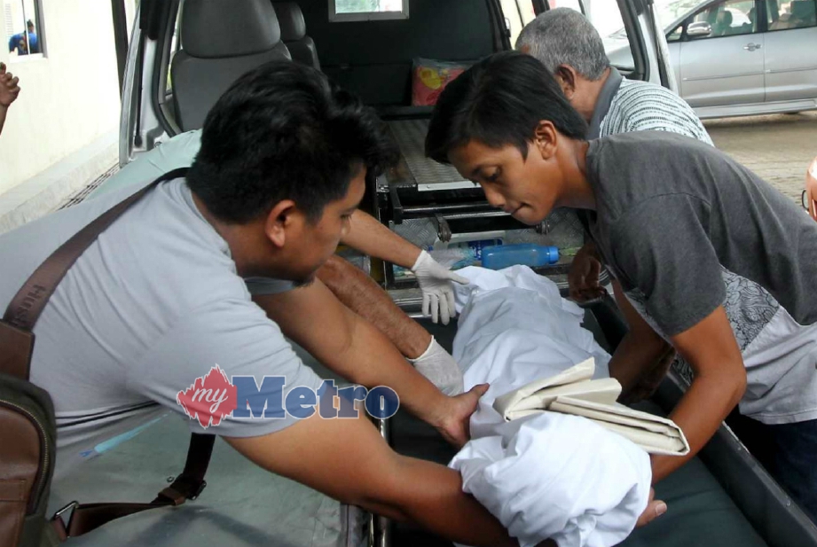 MOHD Asyraf (kiri) mengangkat jenazah Muhammad Luthhakim keluar dari Unit Forensik Hospital Tengku Ampuan Afzan (HTAA), Kuantan, selepas selesai bedah siasat, hari ini. FOTO Muhd Asyraf Sawal.