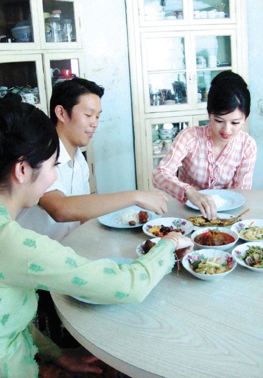 KELUARGA Cina Peranakan Terengganu menggunakan tangan untuk makan.