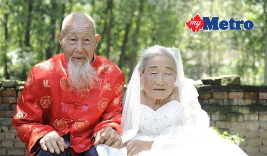 SONG (kiri) dan isterinya mengambil gambar perkahwinan selepas 80 tahun hidup bersama. FOTO People's Daily Online.