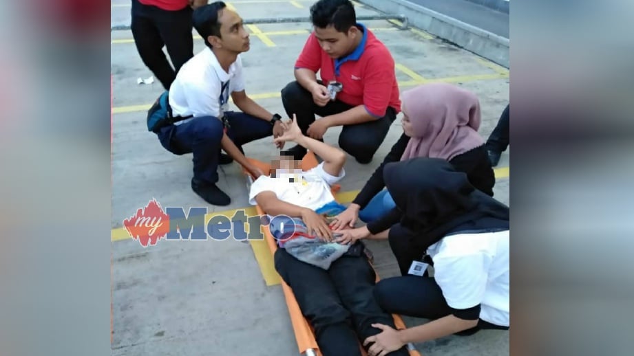 MANGSA yang cedera di bahagian kiri perut dibantu kakitangan pasar raya itu sebelum dihantar ke Hospital Sultan Abdul Halim (HSAH) Sungai Petani, hari ini. FOTO Ihsan Pembaca
