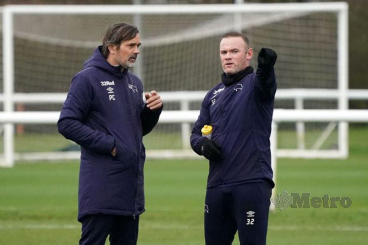 Cocu (kiri) berbincang sesuatu bersama Rooney. FOTO Agensi