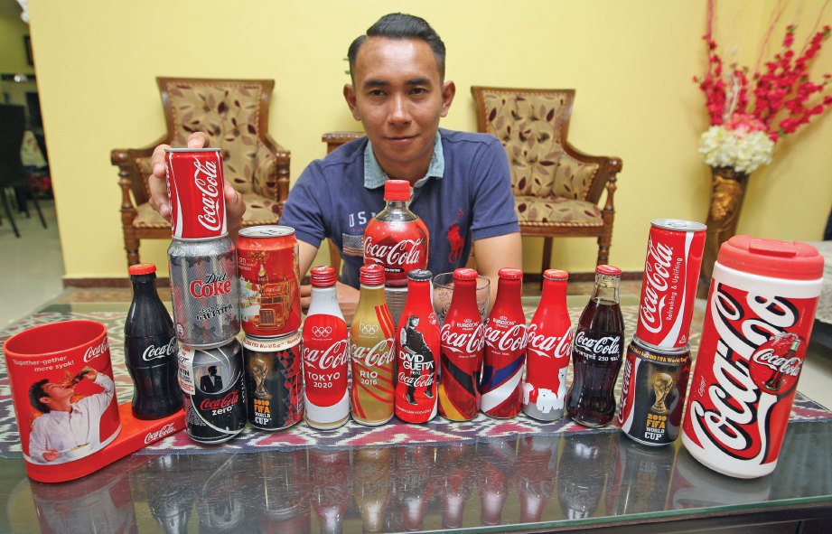 MOHD Azrul bersama koleksi tin dan botol minuman Coca-Cola kepunyaannya. 