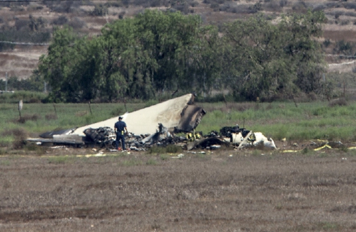 Authorities investigate the crash site where a twin-engine Sabreliner collided with a single-engine Cessna 172 as both were on approach to land at Brown Field, in Otay Mesa, California August 17, 2015. The death toll from the mid-air collision between an executive jet used by military contractor BAE Systems Inc and a small plane over Southern California on Sunday has risen to five, according to a fire department spokesman.  REUTERS/Mike Blake