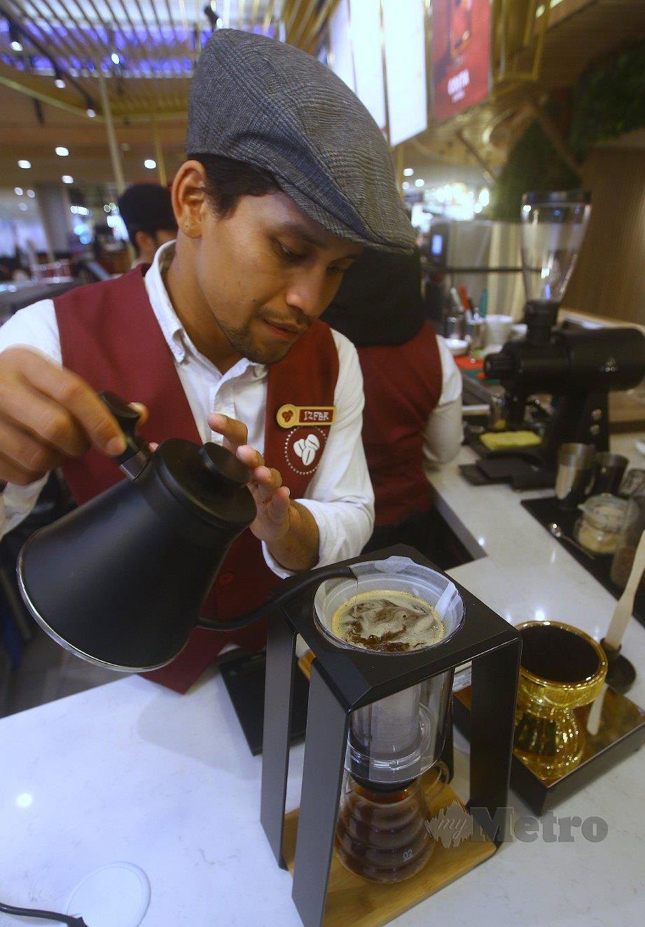 BARISTA Maestro, Mohd Izfar melakukan proses membuat kopi. FOTO Nur Adibah Ahmad Izam.