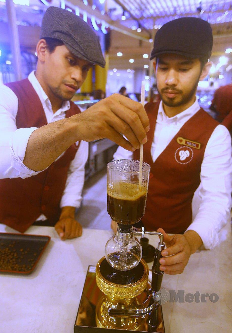 BARISTA Maestro, Mohd Izfar (kiri) bersama Na’im Azimi melakukan proses membuat kopi. FOTO Nur Adibah Ahmad Izam.