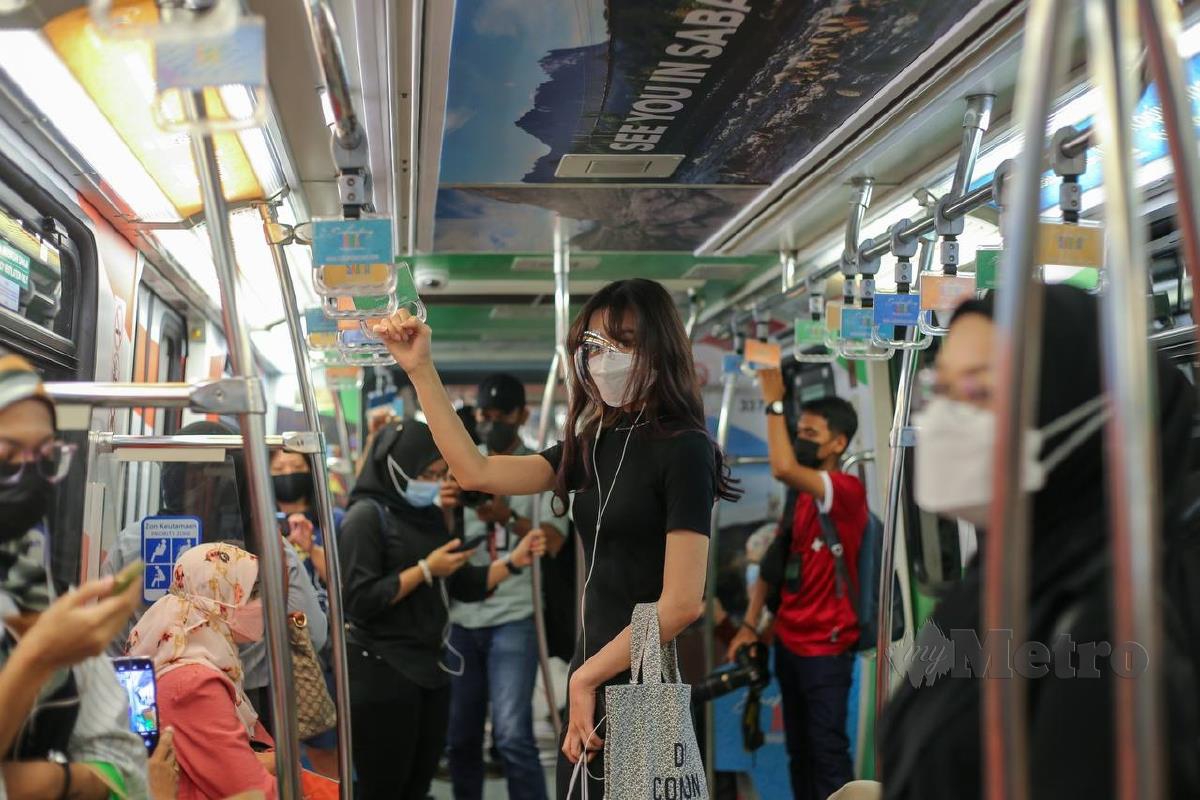 KEADAAN orang ramai menaiki tren Transit Aliran Ringan (LRT) susulan peralihan kepada Fasa 2 Pelan Pemulihan Negara (PPN) di Lembah Klang, bermula hari ini. FOTO ASWADI ALIAS.