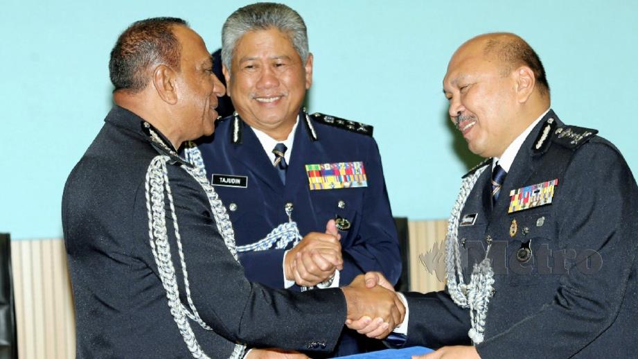 Mohd Kamarudin (kanan) menerima surat tugas Ketua Polis Johor baharu daripada bekas Ketua Polis Johor, Datuk Mohd Khalil Kader Mohd (kiri) sambil disaksikan Tajudin. FOTO Zain Ahmed