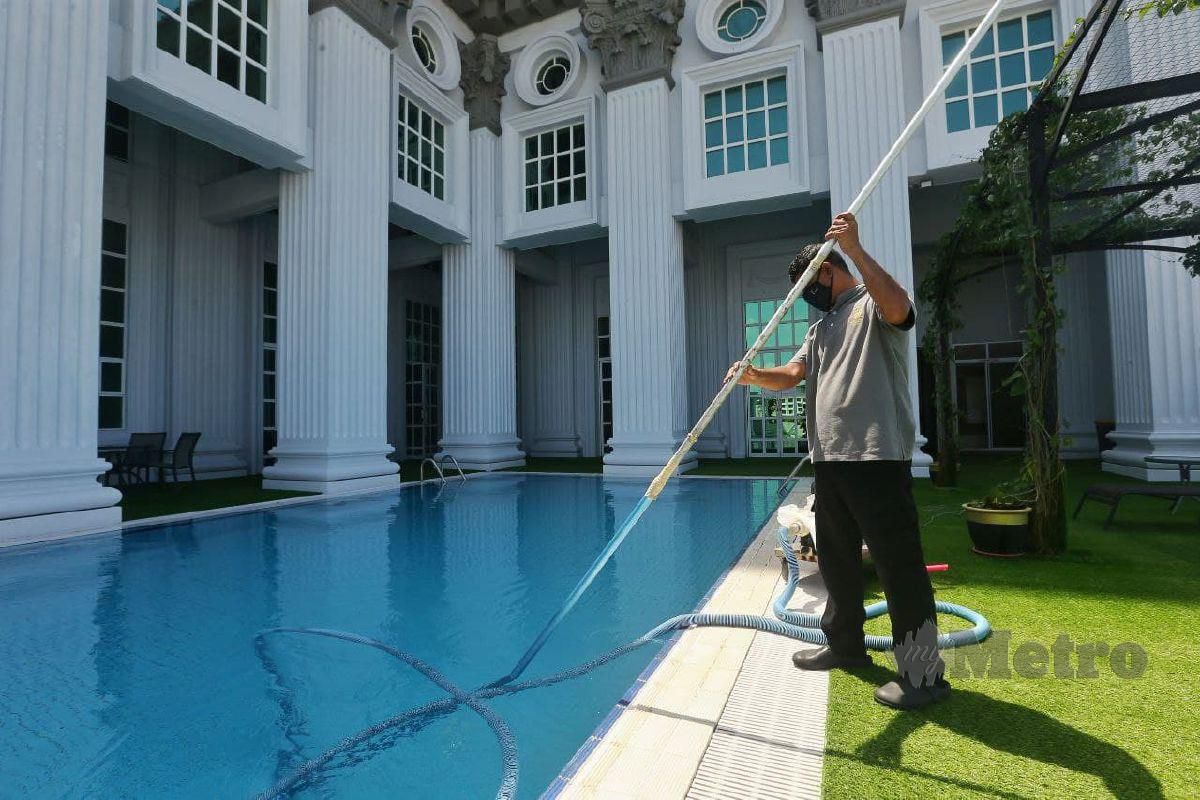 PEKERJA Hotel LaCrista membersihkan kawasan kolam renang susulan sektor pelancongan di Melaka akan dibuka mulai 1 Oktober. FOTO SYAFEEQ AHMAD
