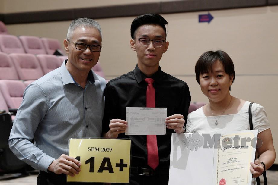 ZHI Han (tengah) bergambar bersama ibu bapanya Magdalene Yee (kanan) dan Ting Sing Moh selepas memperolehi keputusan 11A dalam SPM 2019.
