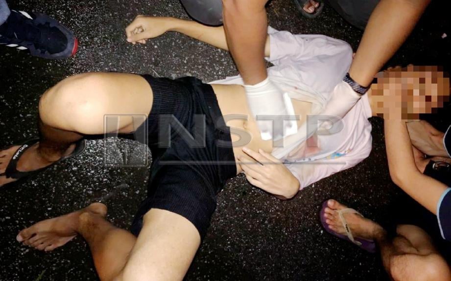 MANGSA diberikan rawatan awal selepas ditikam di perut dengan senjata tajam oleh dua lelaki selepas dipercayai enggan menyerahkan telefon bimbit dalam kejadian di hadapan SMK Alang Iskandar, Jalan Siakap, Bagan Serai, malam tadi. FOTO ihsan pembaca. 