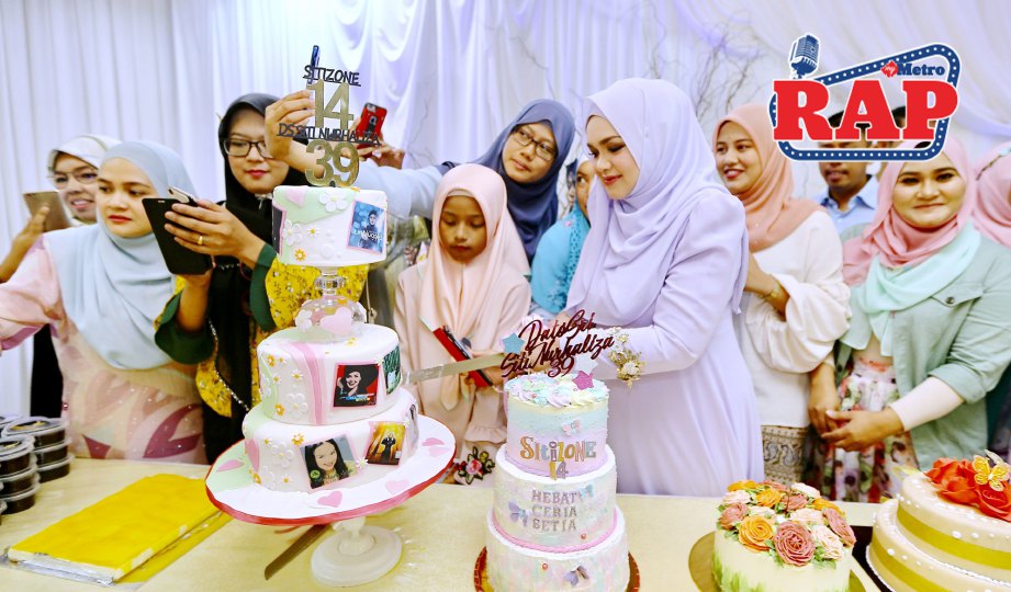 SITI memotong kek sempena ulang tahun ke-14 Sitizone. FOTO Mohd Khairul Helmy Mohd Din