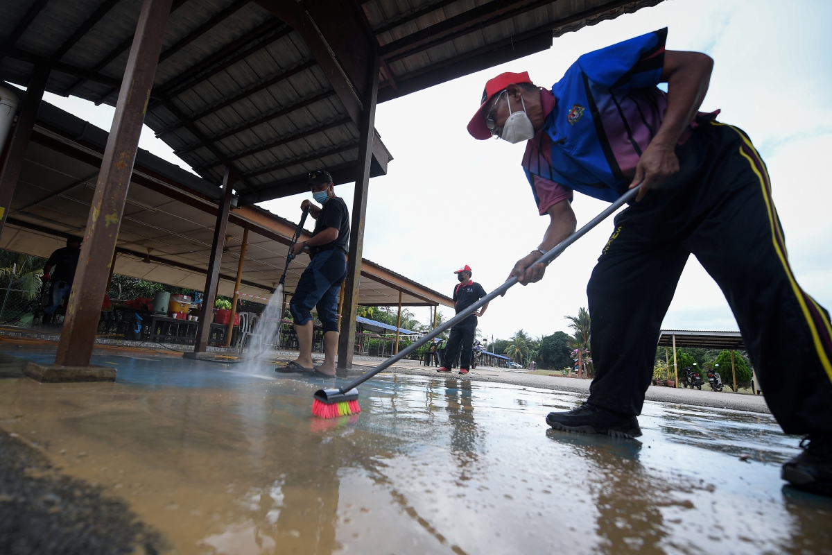GURU melakukan proses pembersihan di Sekolah Kebangsaan Kuala Paya, Segamat yang terjejas banjir ketika tinjauan semalam. FOTO BERNAMA