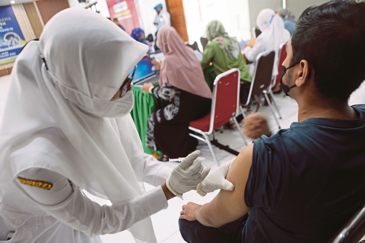 PETUGAS kesihatan menyuntik vaksin Covid-19 dalam program vaksinasi di Banda Aceh. FOTO EPA 