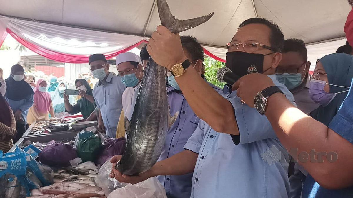 Ahmad Hamzah (kanan) bersama Che Abdullah sedang melelong ikan yang dijual di Jeti Pendaratan Ikan Lembaga Kemajuan Ikan Malaysia (LKIM), Tanjung Che Mas, sempena program MAFI Prihatin Nelayan Parlimen Tumpat hari ini. FOTO SITI ROHANA IDRIS