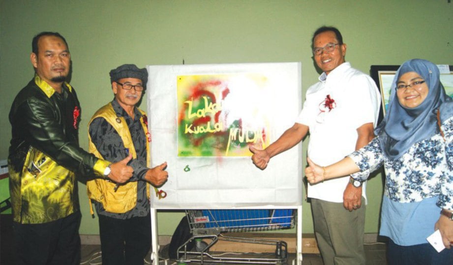 RAMLI (kiri) sewaktu mengiringi gimik perasmian pameran Lakaran Daerah Kuala Muda oleh Tajul Urus (dua dari kanan).
