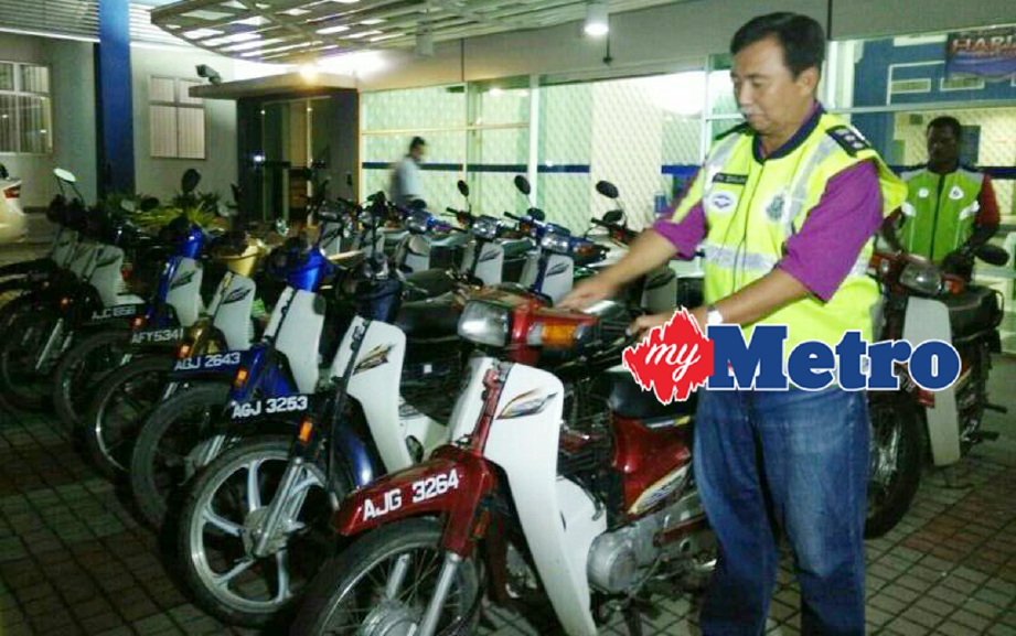 Ketua Polis Daerah Manjung Asisten Komisioner Tengku Mohd Zailan menunjukkan motosikal dipercayai dicuri yang digunakan pendatang asing di sebuah ladang kepala sawit di Pantai Remis. - Foto NOOR HIDAYAH TANZIZI