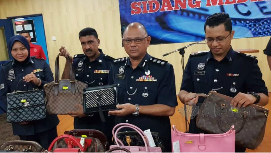 MOHD Fahmi (dua kanan) menunjukkan beg tangan berjenama yang dicuri pegawai tentera pada sidang media, hari ini. FOTO Nurul Hidayah Bahaudin.