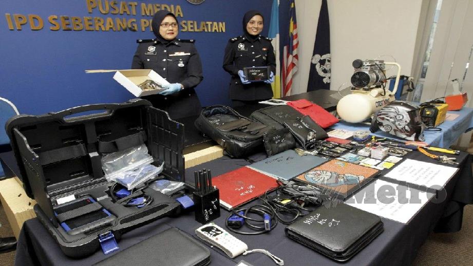 BAEYAH (kiri) menunjukkan barangan yang dirampas termasuk sepucuk pistol tiruan dan alat pengatur cara untuk mencuri kenderaan pada sidang media, hari ini. FOTO Danial Saad.