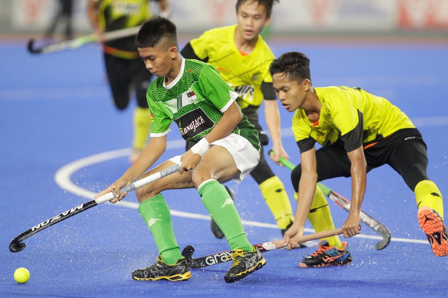 PEMAIN Perak, Azmil Muizzuddin Misron (kanan) cuba mendapatkan bola daripada pemain Melaka, Muhammad Iqram Yahaya pada Kejohanan Hoki Lelaki dan Wanita Bawah 16 tahun Kebangsaan di Stadium Hoki Nasional Bukit Jalil, Kuala Lumpur. -Foto AIZUDDIN SAAD