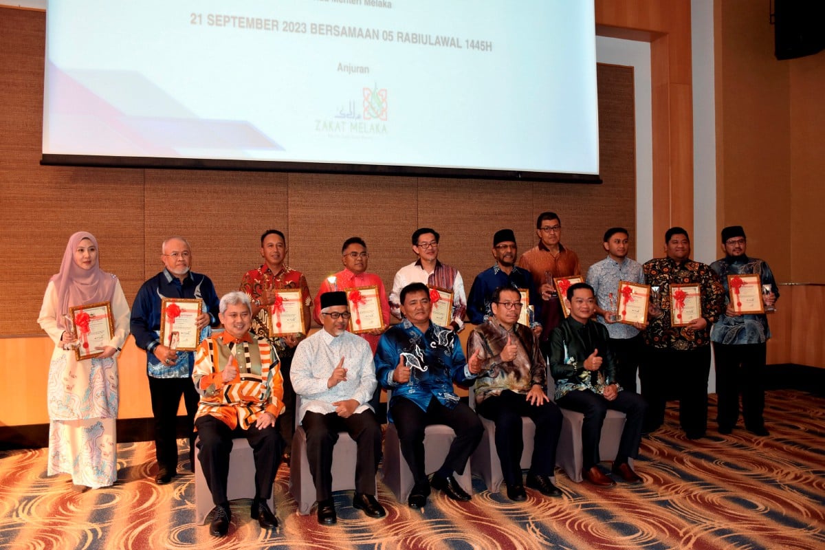 Rahmad (duduk, tengah) bersama penerima anugerah pembayaran zakat pada Majlis Anugerah Zakat Melaka Sektor Awam dan Swasta Tahun 2022 di sini malam ini. FOTO BERNAMA