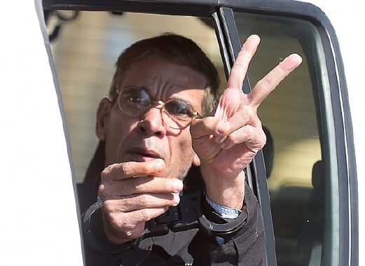 Seif al-Din Mohamed Mostafa membuat lambang V dengan tangannya yang bergari ketika dibawa meninggalkan mahkamah hari ini.