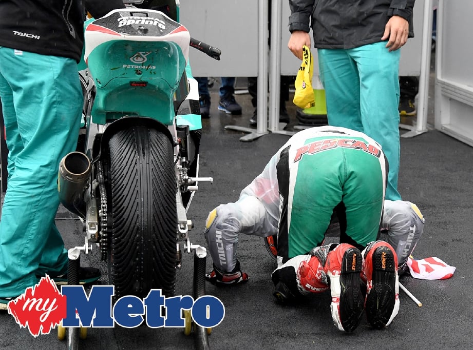 HAFIZH sujud syukur selepas duduki tempat ketiga acara Moto2 di Litar Motegi. -Foto AFP