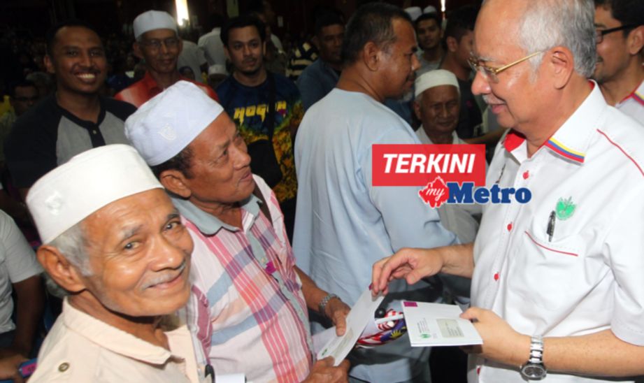 PERDANA Menteri, Datuk Seri Najib Razak menyampaikan dividen kepada pekebun kecil di Dewan Konvensyen Sultan Haji Ahmad Shah. FOTO Farizul Hafiz Awang