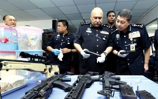 MOHD Mokhtar menunjukkan pistol dan senapang yang dirampas dalam serbuan di makmal memproses dadah.