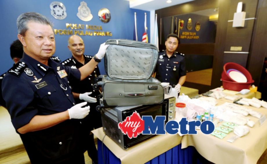KETUA Polis Pulau Pinang, Datuk Wira Chuah Ghee Lye (kiri) menunjukkan beg  yang digunakan untuk menyimpan dadah jenis heroin. FOTO Mikail Ong